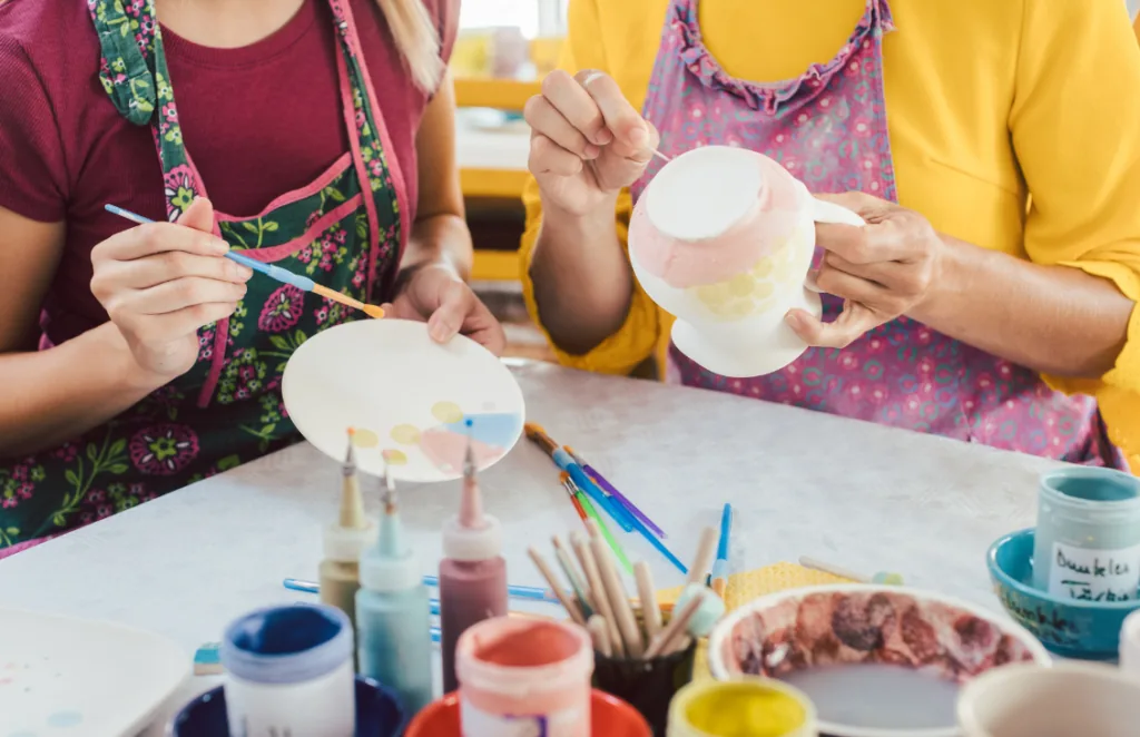 Families painting pottery together at From the Art Studio